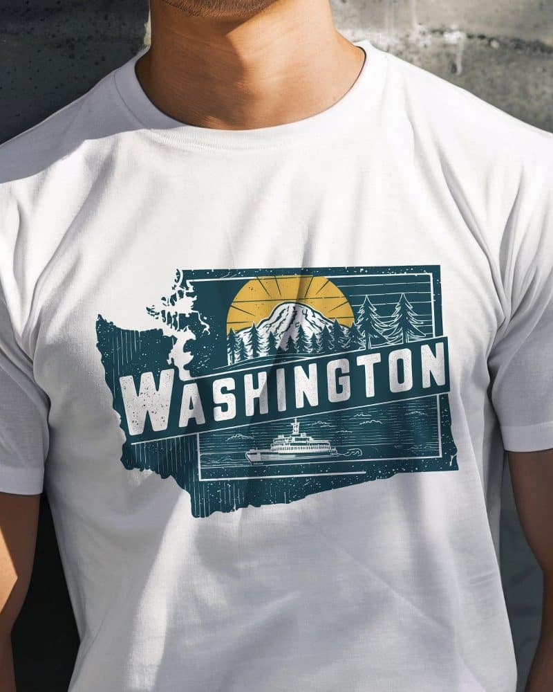 White t-shirt with a graphic design of the Washington state outline featuring a mountain, sun, trees, and ferry.