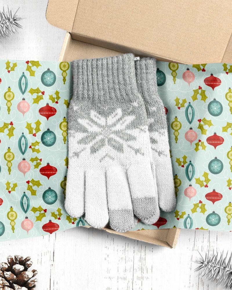 Pair of gray and white knit gloves in a Christmas gift box.