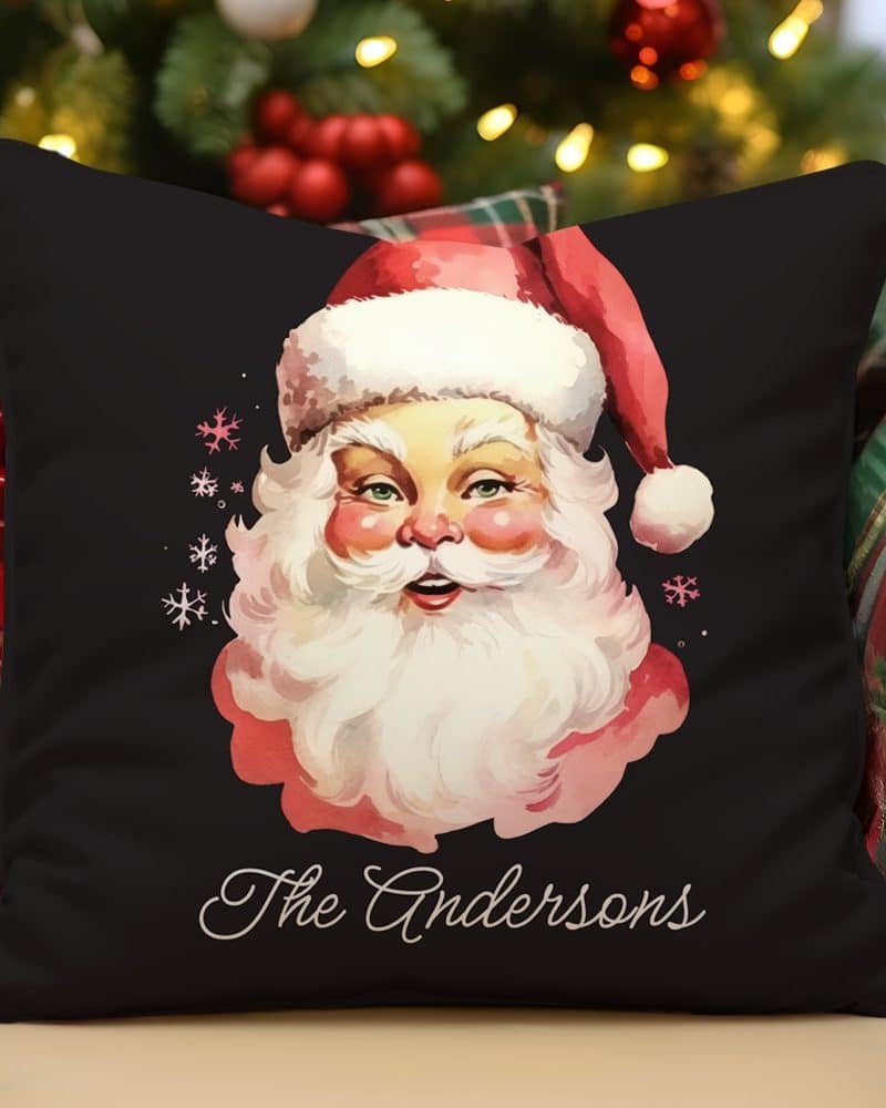 Black pillow with a vintage illustration of Santa Claus and the name Andersons.