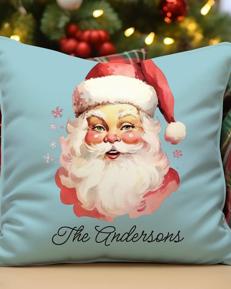 Light blue pillow featuring a vintage illustration of Santa Claus, with the name Andersons printed below.