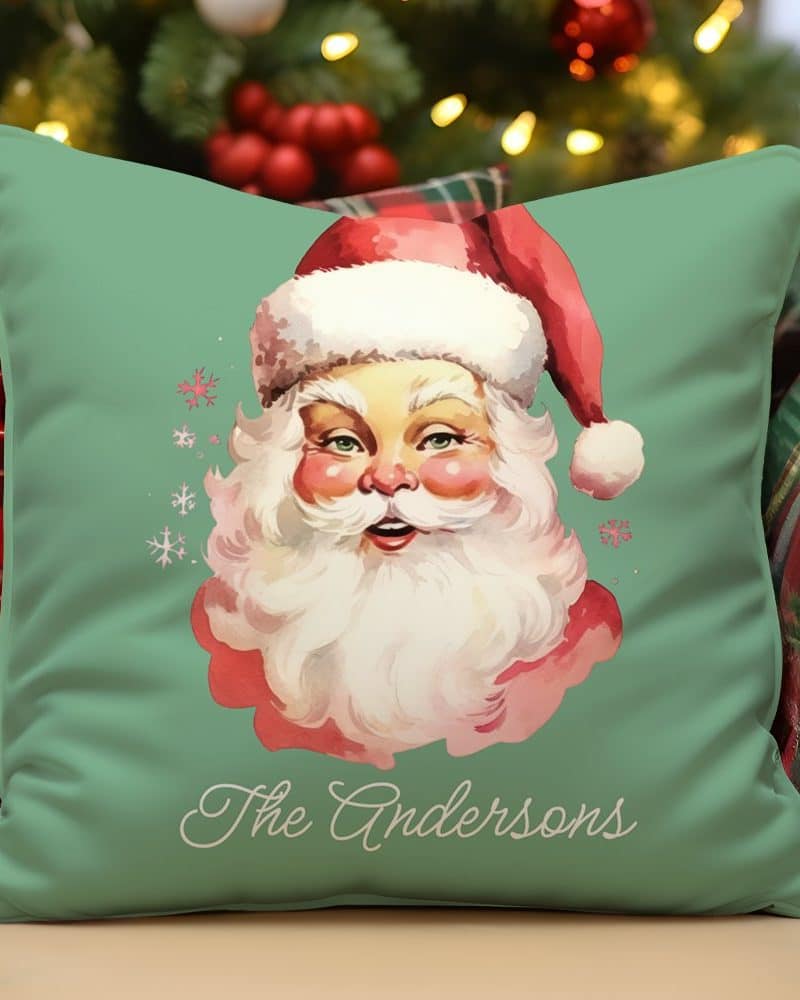Green pillow with a vintage illustration of Santa Claus's face and the name Andersons.