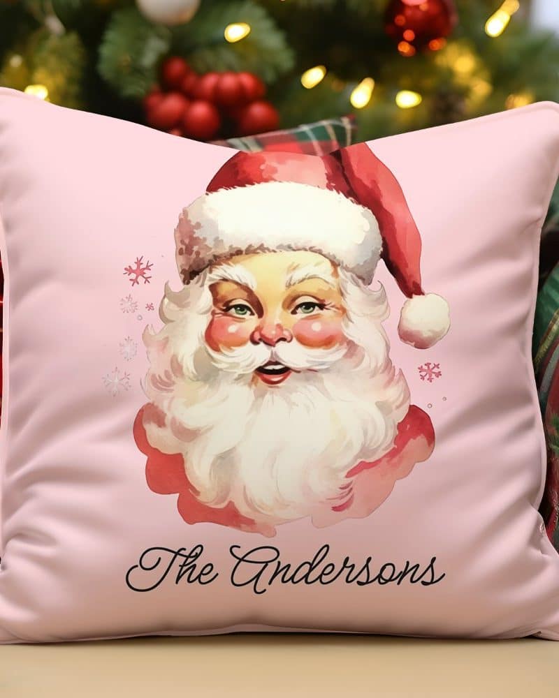 Pink pillow with a vintage illustration of Santa Claus and the name Andersons.