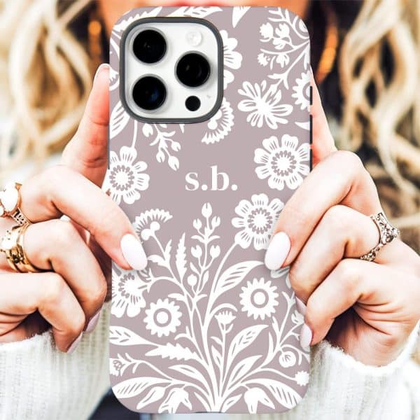 A Mauve Iphone Case With A White Floral Pattern And Initials S.b.