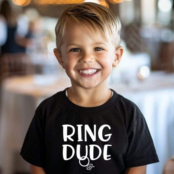 Smiling Young Boy Wearing A Black T-Shirt That Says Ring Dude.