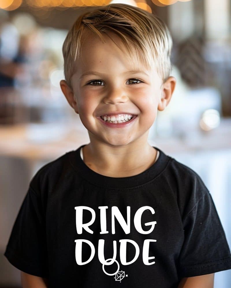 Smiling young boy wearing a black t-shirt that says Ring Dude.