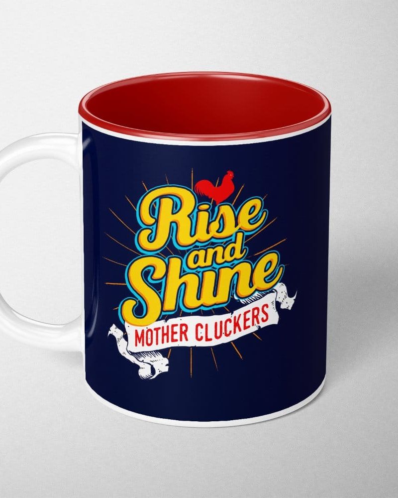 Dark blue mug with a red interior, featuring the text Rise and Shine with a rooster illustration and the words Mother Cluckers.