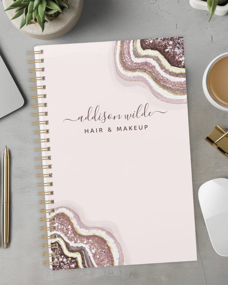 Spiral-bound notebook with pink agate design and Addison Wilde Hair & Makeup lettering.