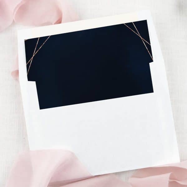 A White Envelope With A Navy Blue Inner Liner And Rose Gold Accents.