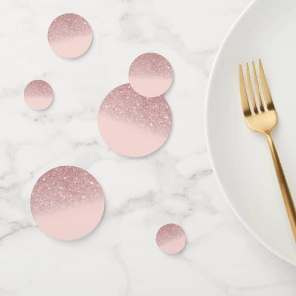 Rose Gold Glitter Confetti Circles On A Marble Surface Next To A Gold Fork And White Plate.
