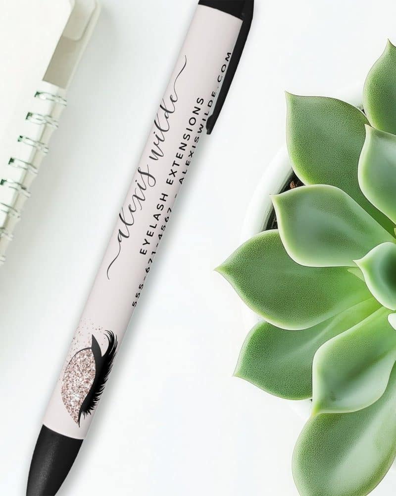 A pen with Alexis Wilde's name and Eyelash Extensions business information printed on it.
