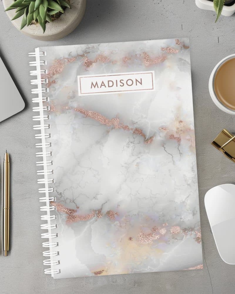 Spiral notebook with a rose gold marble design and the name Madison on the cover.