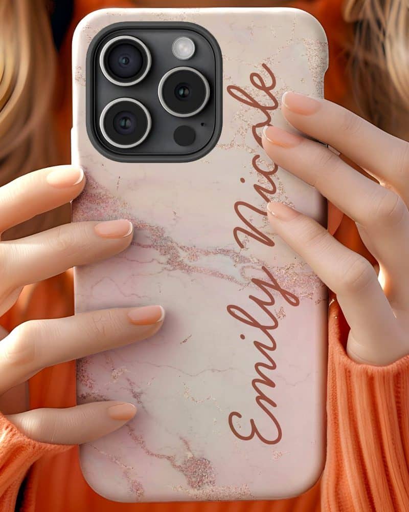 Person holding a pink marble iPhone case with the name Emily Nicole written on it.