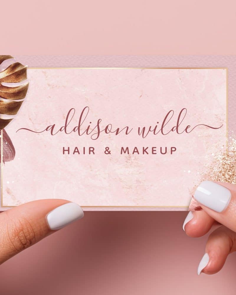 Pink business card for Addison Wilde Hair & Makeup, featuring gold leaf and glitter accents.