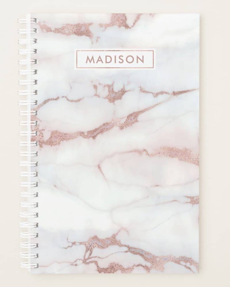 Rose gold marble spiral notebook with the name Madison on the cover.