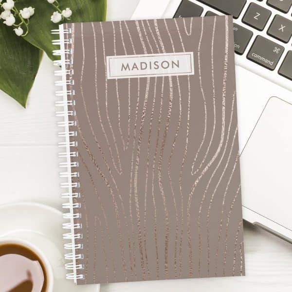 Spiral-Bound Notebook With A Taupe Cover And Rose Gold Wood Grain Design. The Name Madison Is Printed On The Cover.