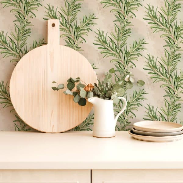 Large Round Wooden Board And White Pitcher With Eucalyptus Sprigs, Set Against A Rosemary Patterned Wall.