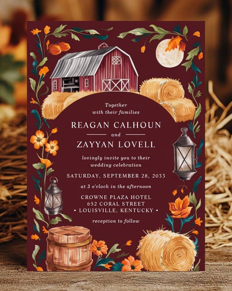 Wedding invitation with a barn, hay bales, and lanterns; burgundy background with autumnal floral accents.