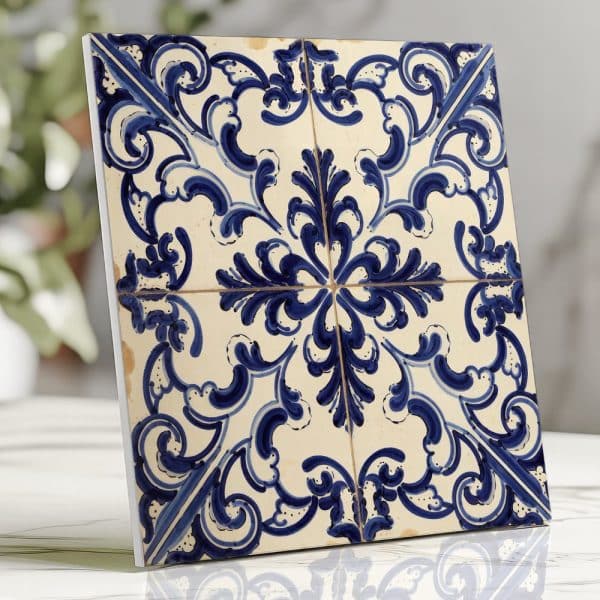 A Square Tile With A Blue And White Floral Design.