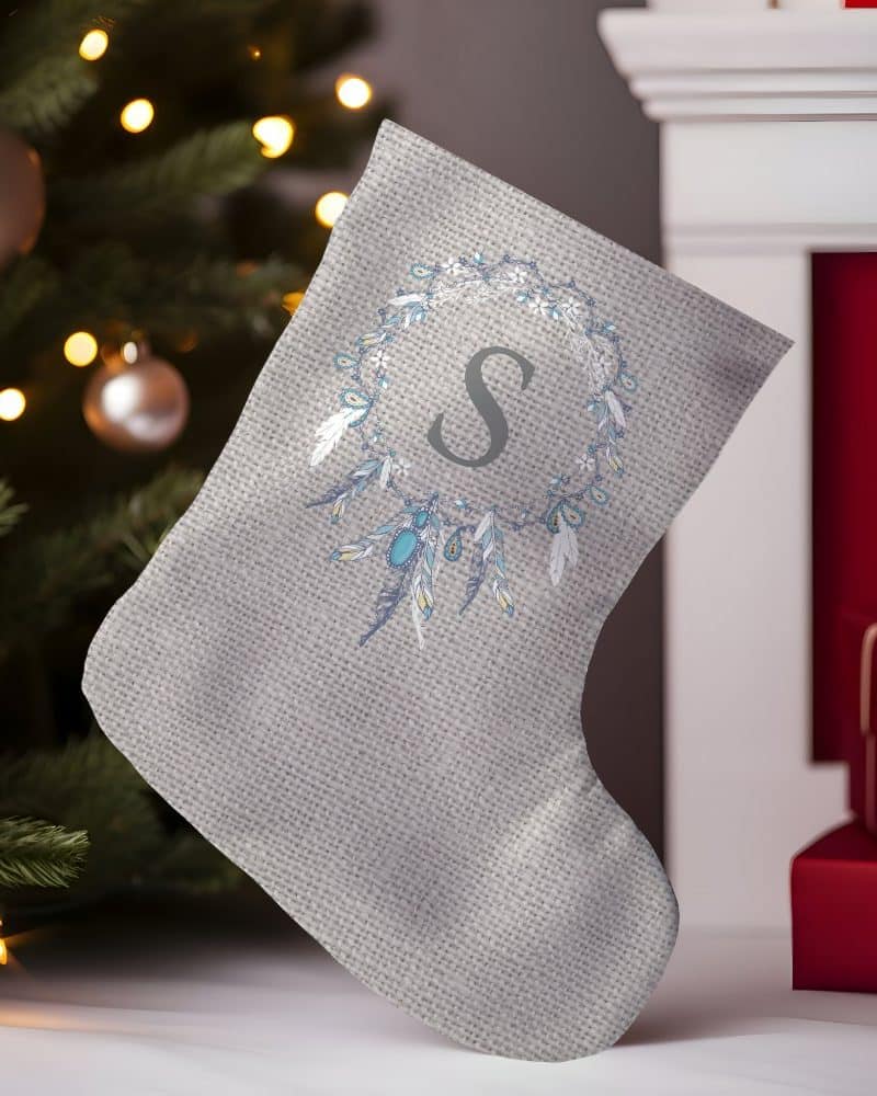 Gray Christmas stocking with a feather and jewel design and the initial S.