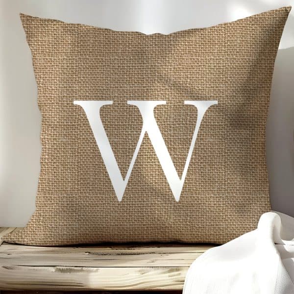 Beige Burlap Pillow With A Large White Letter W.