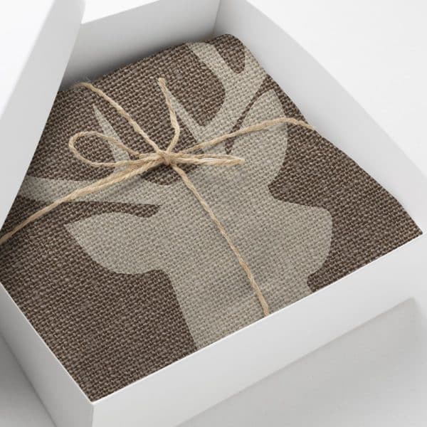 Brown Fabric With A Beige Deer Design, Tied With Twine, In A White Gift Box.