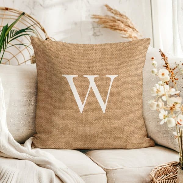 Beige Burlap Pillow With A Large White Letter W.