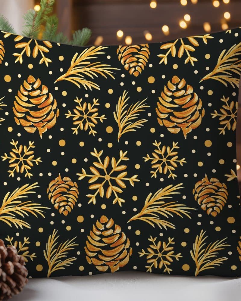 Gold pine cones and snowflakes on a black throw pillow.