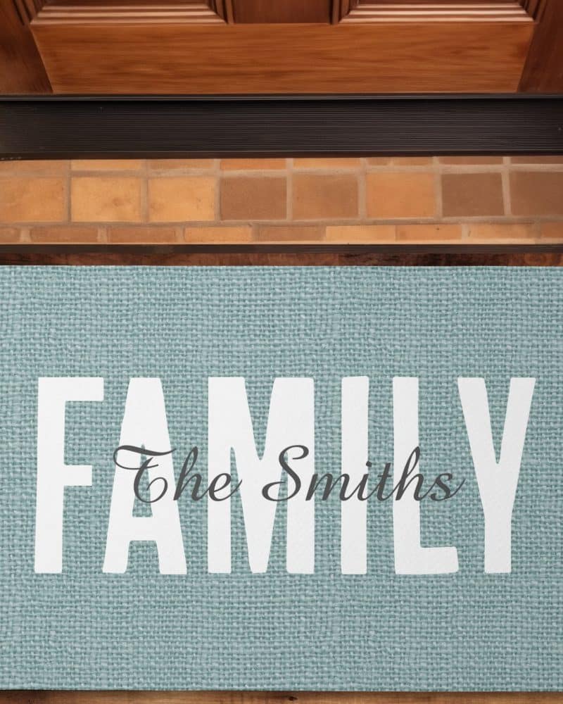 Light blue doormat with the word FAMILY in large white letters and The Smiths in a smaller, cursive font underneath.