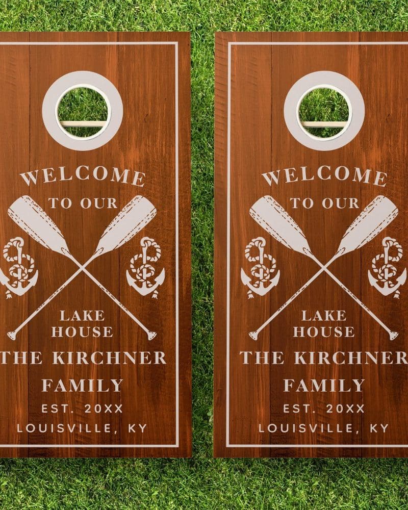 Two wooden cornhole boards with a welcome message, crossed oars, anchors, and the Kirchners family name and location.
