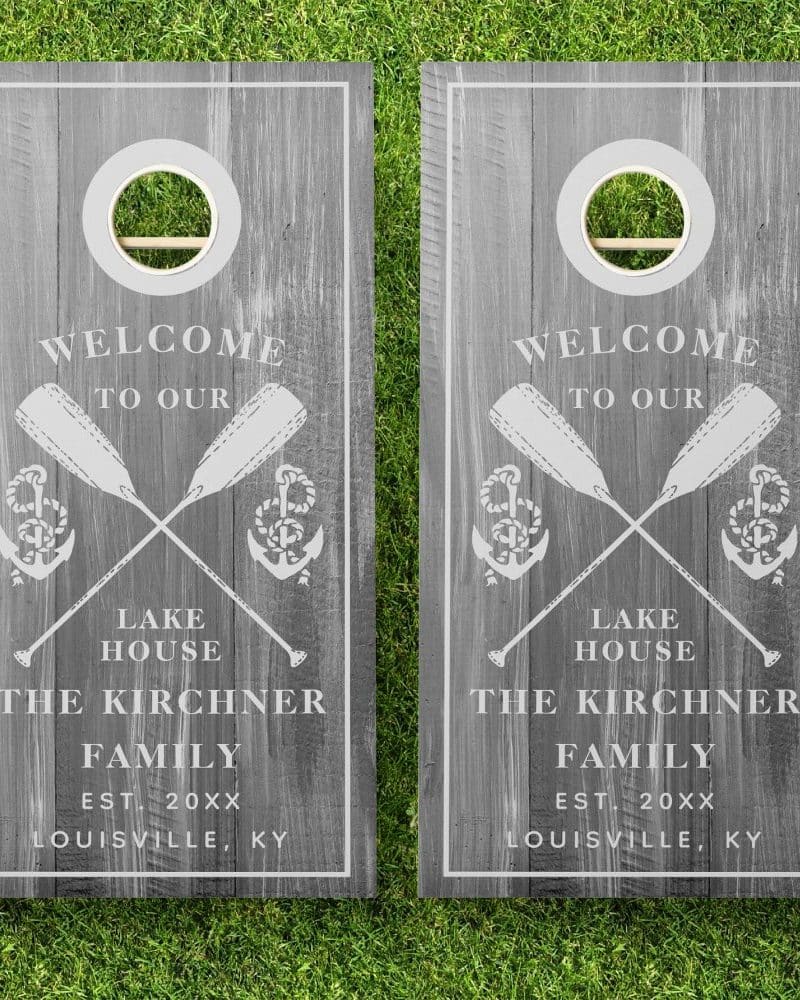 Two gray wooden cornhole boards with a welcome message, crossed oars, anchors, and the Kirchner family name.