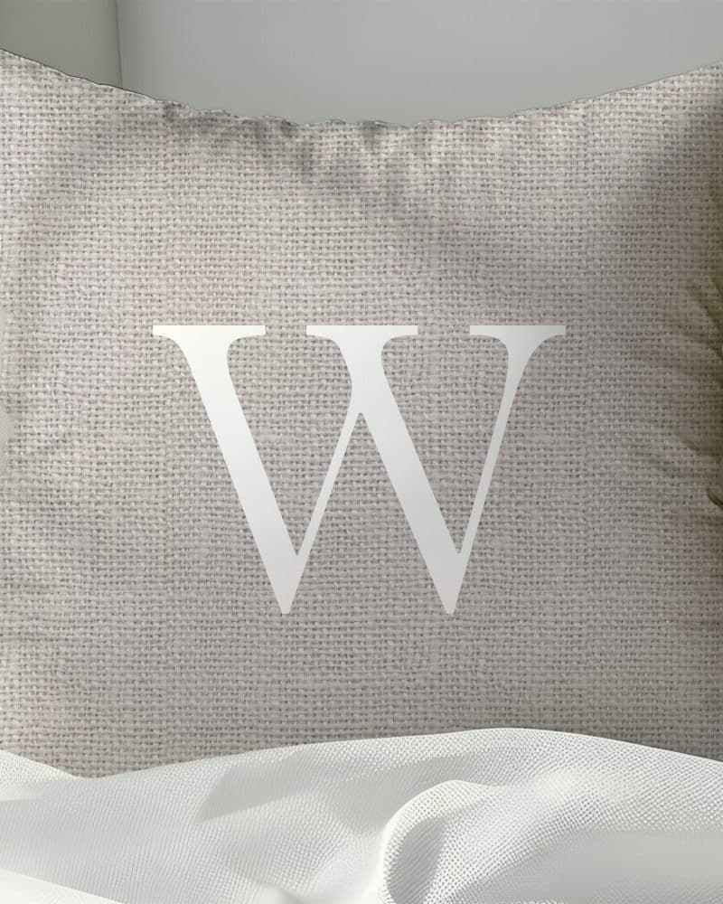 Beige pillow with a large white letter W.