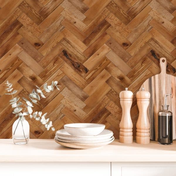 Brown Herringbone Wood Pattern Backdrop With Stacked Dishes, Eucalyptus Sprigs In A Vase, And Kitchen Utensils.