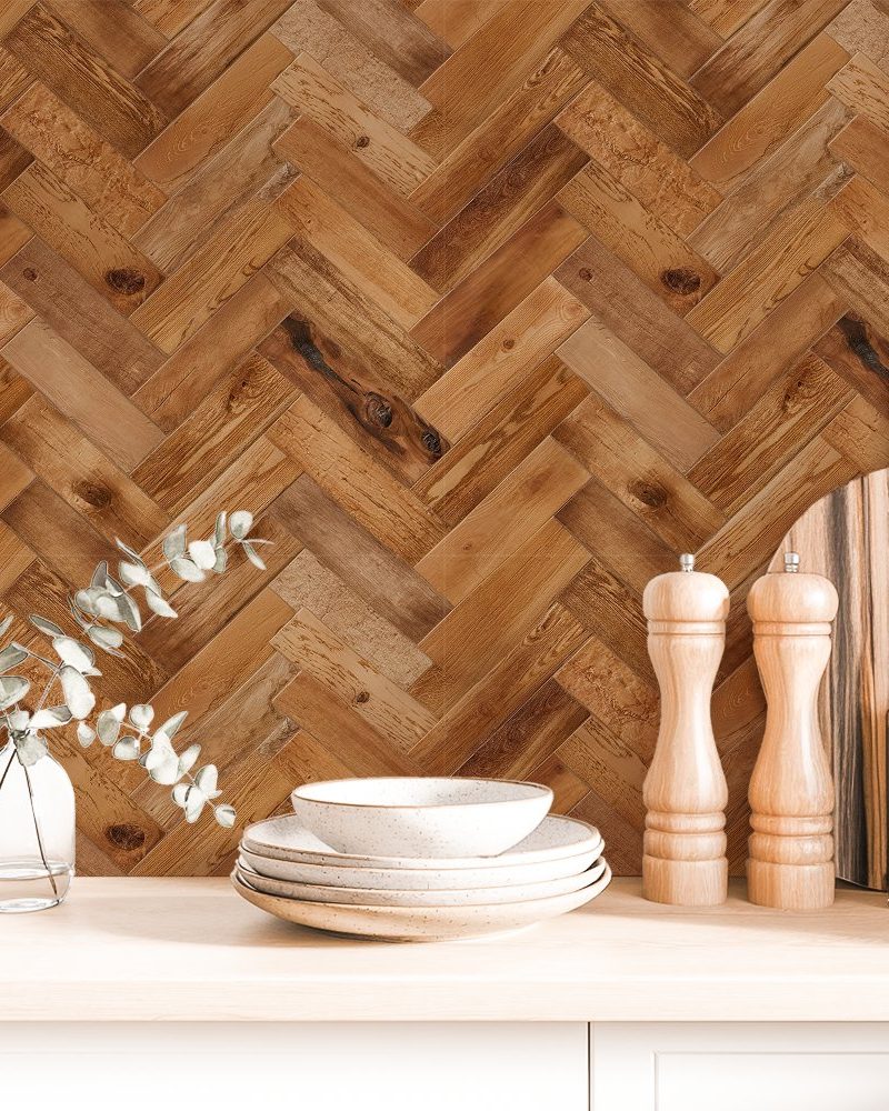 Brown herringbone wood pattern backdrop with stacked dishes, eucalyptus sprigs in a vase, and kitchen utensils.