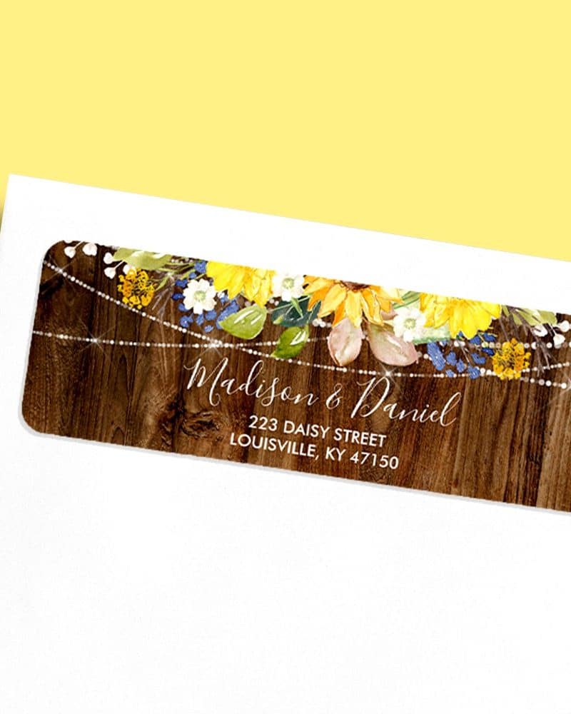Return address label with sunflowers and string lights on a wood background, showing Madison & Daniel's address.