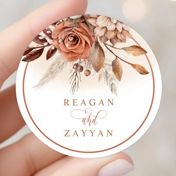 Round Wedding Favor Tag With Autumnal Floral Design And The Names Reagan And Zayyan.