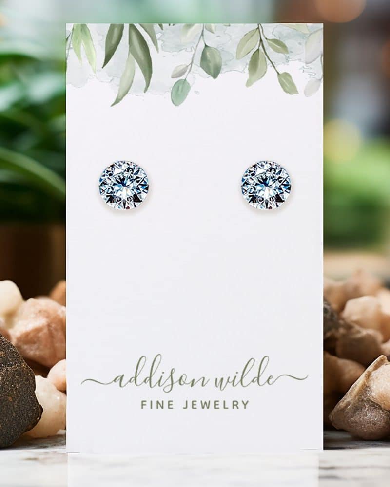 Pair of round, clear stud earrings displayed on a jewelry card.