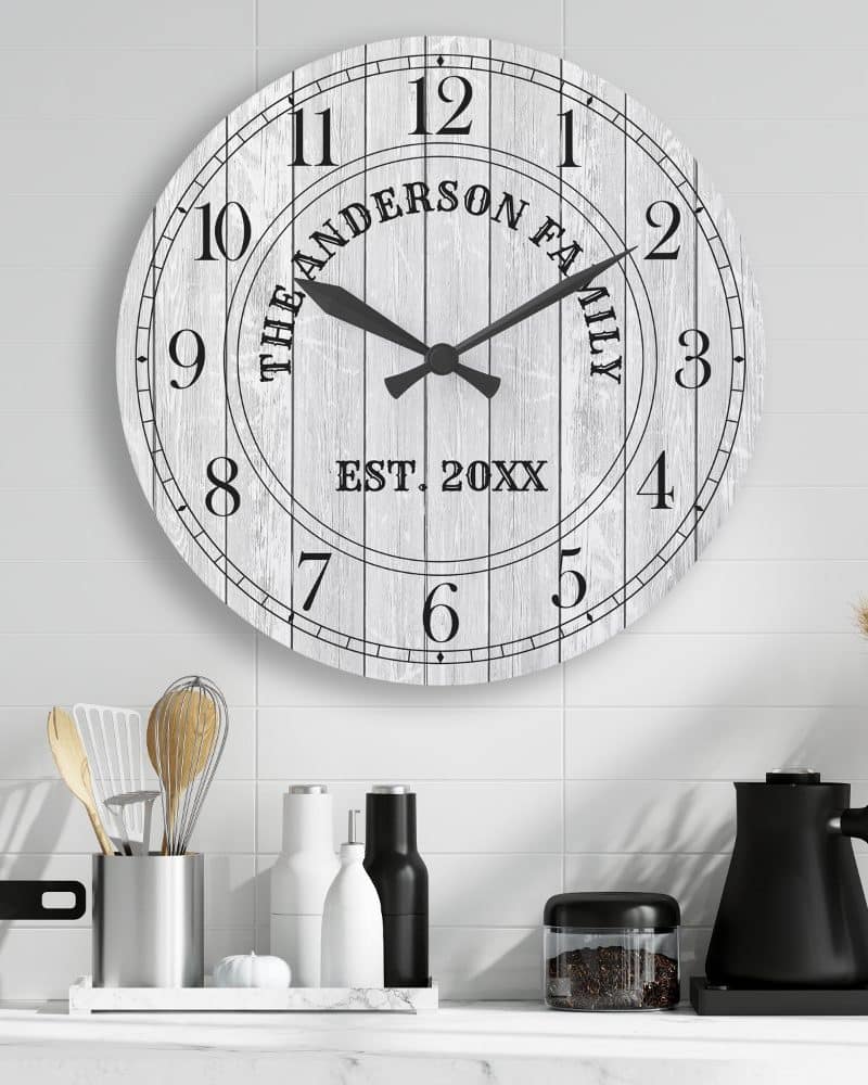 Large white wooden wall clock with black hands and family name.