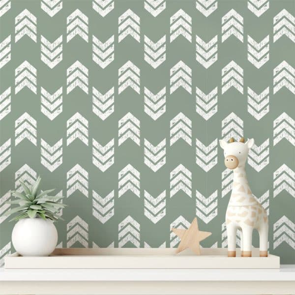 Sage Green Wall With A Repeating Pattern Of White Distressed Chevron Arrows, Featuring A Small Giraffe Toy And A Succulent Plant On A Shelf.