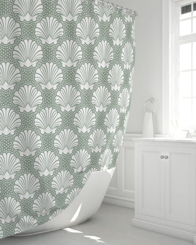 Sage green shower curtain with a repeating pattern of white stylized seashells.