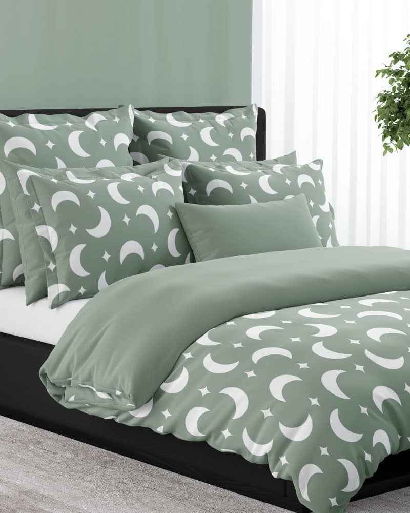 Sage green duvet cover and pillows with a white crescent moon and star pattern.