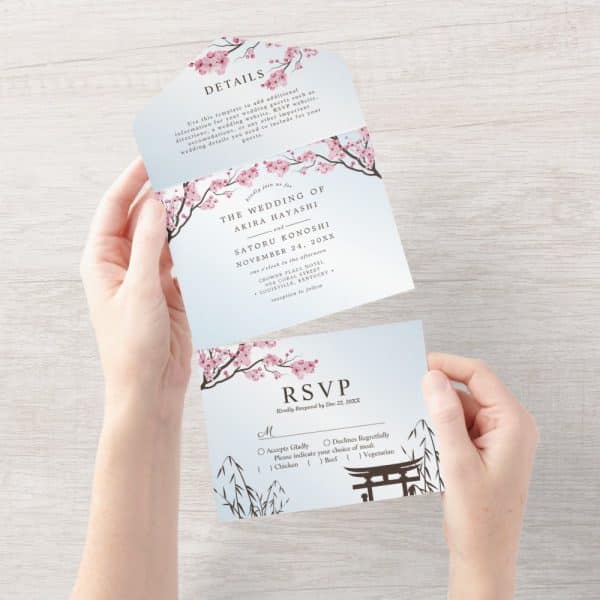 Tri-Fold Wedding Invitation With Pink Cherry Blossoms And A Light Blue Background. The Invitation Includes The Couple'S Names And Wedding Details, Along With An Rsvp Section.