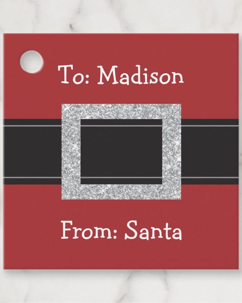 Red gift tag with a silver glitter Santa belt buckle design, personalized for Madison from Santa.