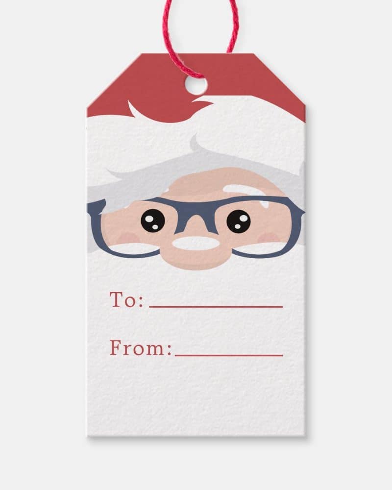 A Christmas gift tag featuring a cartoon Santa Claus's face wearing glasses. The tag includes spaces to write "To:" and "From:".