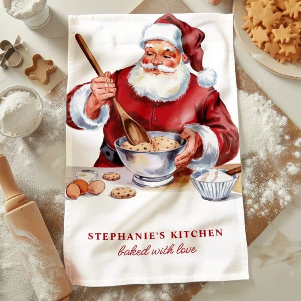 A Kitchen Tea Towel Featuring A Vintage Illustration Of Santa Claus Baking Cookies.