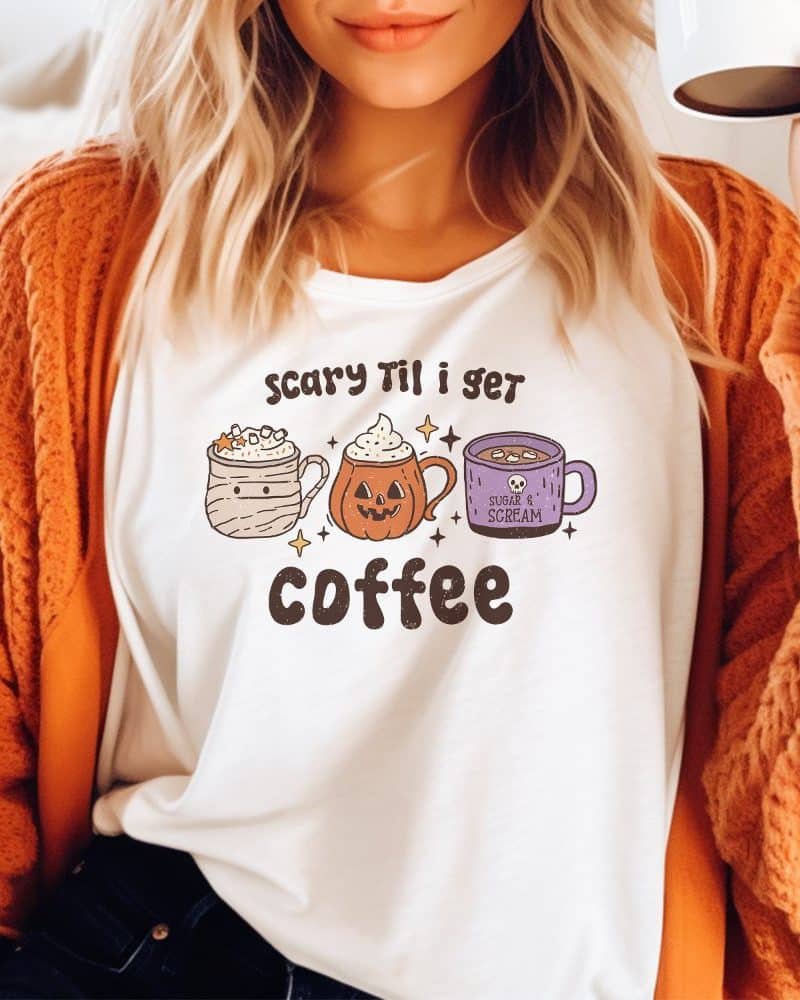 Woman wearing a white shirt with a Halloween-themed coffee design.