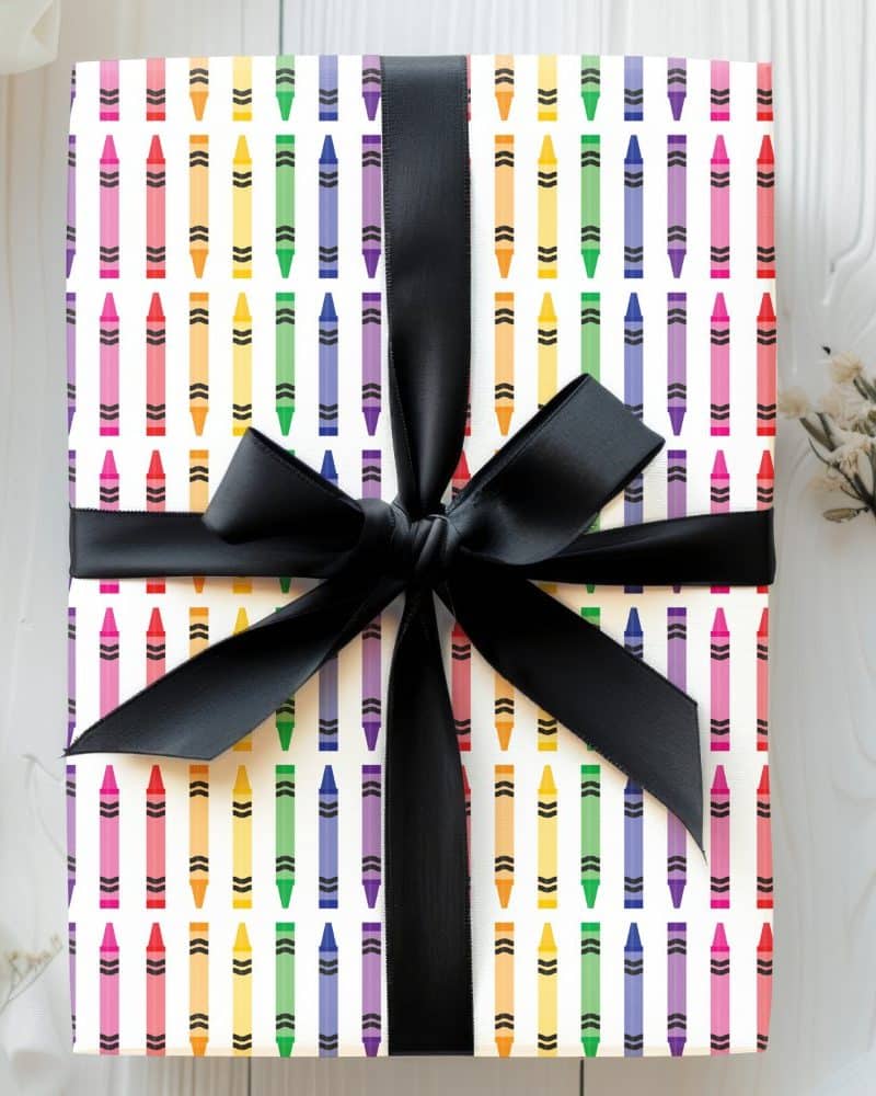 Gift wrapped with crayon patterned paper and a black ribbon.