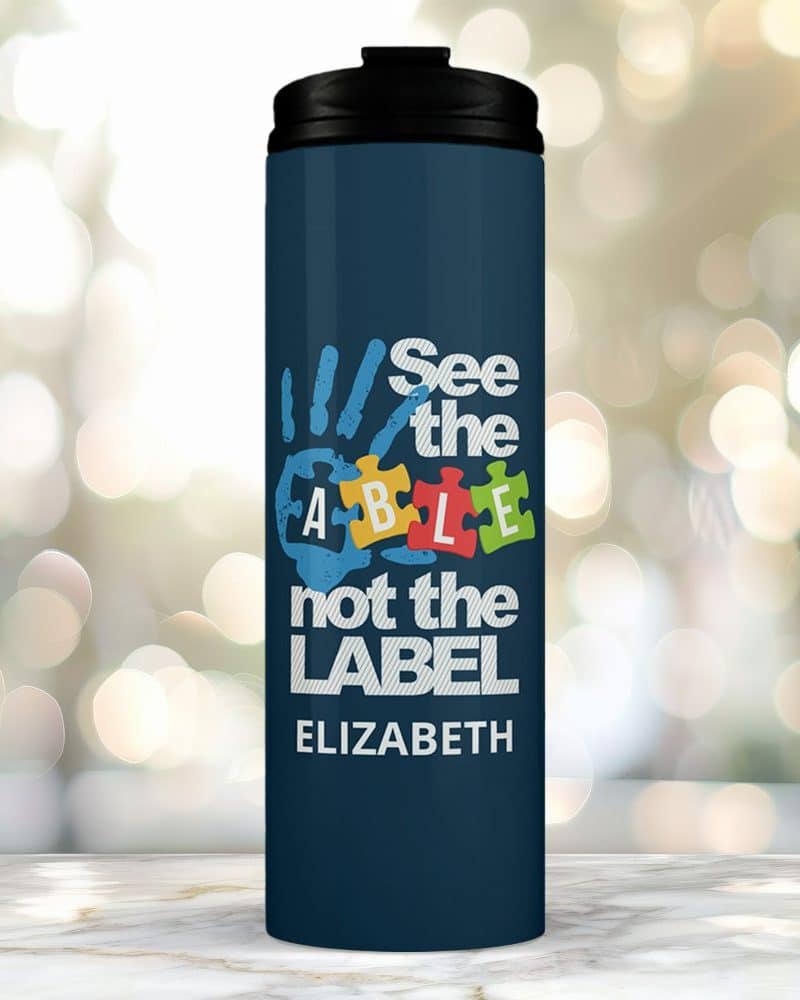 Dark blue travel mug with a handprint graphic incorporating the word able and the text See the able not the label, personalized with the name Elizabeth.