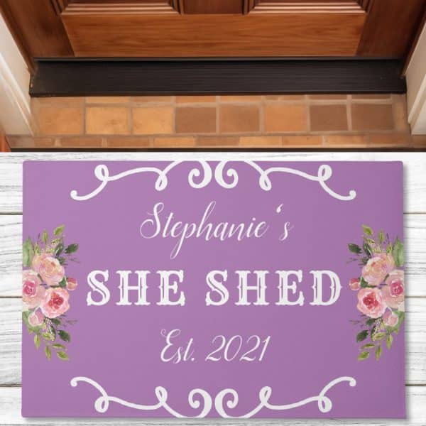 Purple Doormat With Stephanie'S She Shed Est. 2021 In White Lettering And Floral Designs.