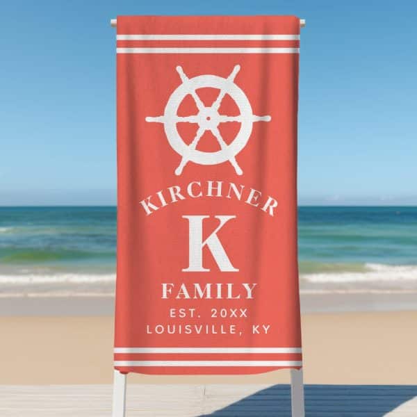 Coral Beach Towel With A Ship'S Wheel, The Letter K, And The Kirchiner Family Name.