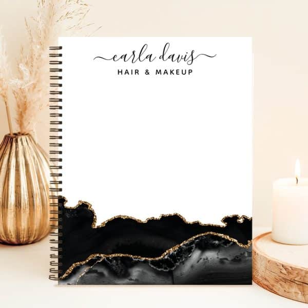 Spiral-Bound Notebook With Carla Davis Hair &Amp; Makeup Logo, Featuring A Black And Gold Agate Design.